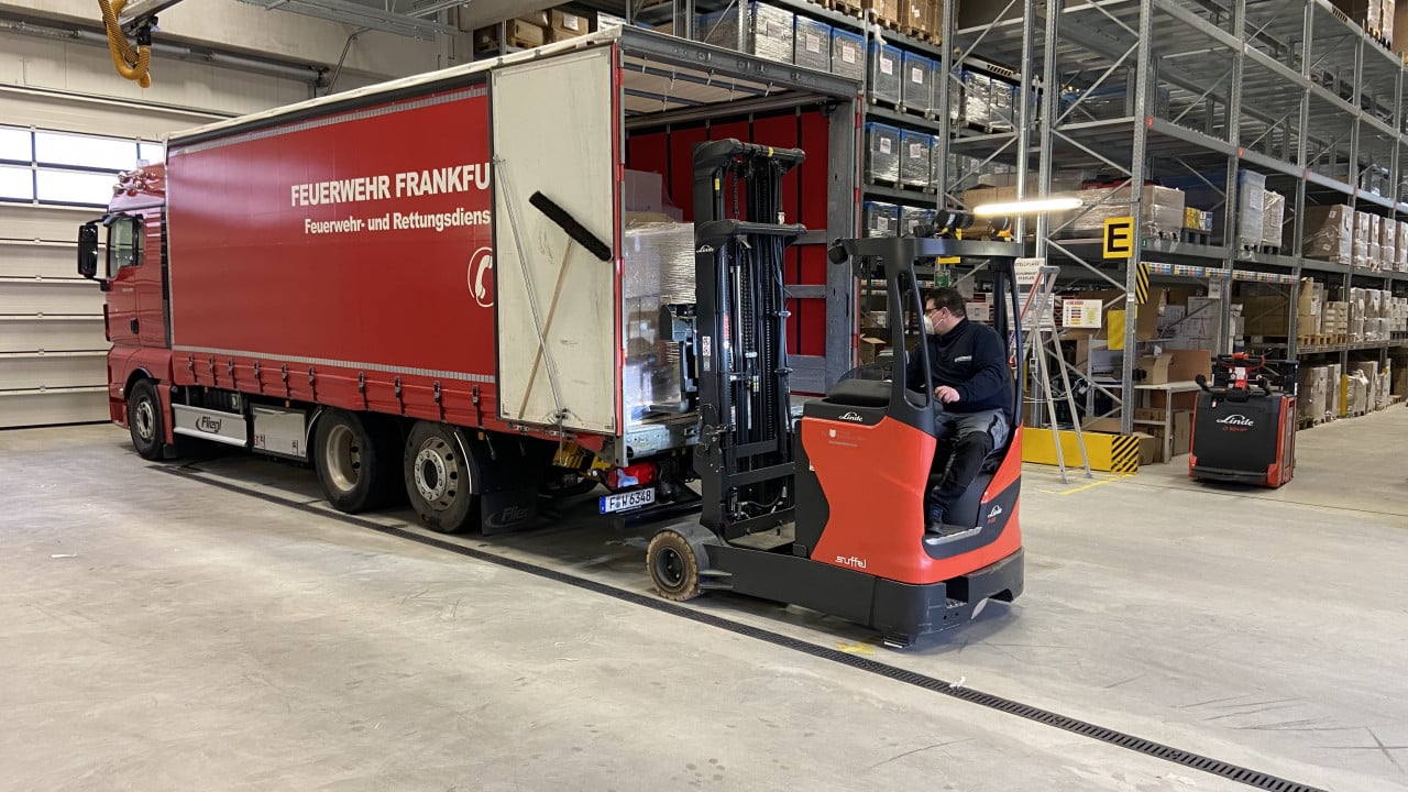 Ein Mitarbeiter vom KatS-Lager beim Beladen des Transportfahrzeugs